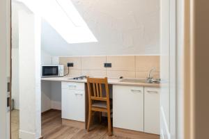 a kitchen with white cabinets and a sink and a microwave at Die Bruckmühle in Valley