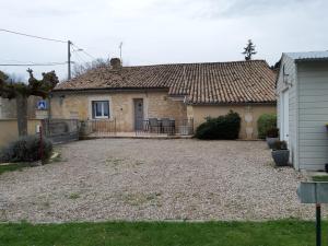 a house with a gravel yard in front of it at Gite Les Deux Meules in Sainte-Colombe