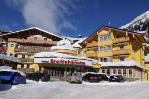 ein großes Gebäude mit Autos auf einem Parkplatz in der Unterkunft Hotel Breitlehenalm in Obertauern