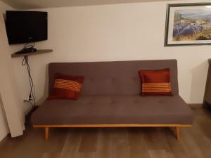 a couch with two pillows sitting in a room at Gite Les Deux Meules in Sainte-Colombe