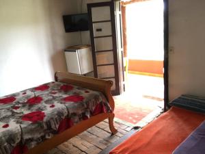 um quarto com uma cama e um pequeno frigorífico em Recanto das Acácias em Guararema