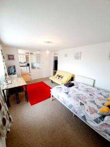 a bedroom with a bed and a red rug at Rayleigh Town Centre 2 Bedroom Apartment in Rayleigh