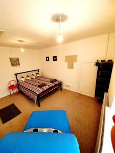 a bedroom with a bed and a blue couch at Rayleigh Town Centre 2 Bedroom Apartment in Rayleigh