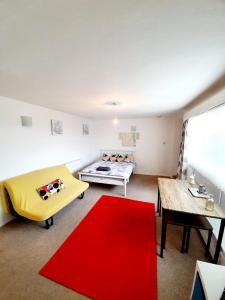 a living room with a couch and a red rug at Rayleigh Town Centre 2 Bedroom Apartment in Rayleigh