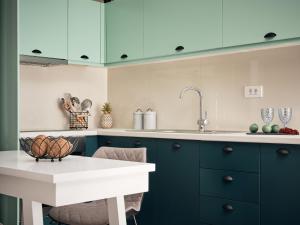 a kitchen with blue cabinets and a white counter at Bella Vista Building A - 100m from Solomos Square, by ZanteWize in Zakynthos Town