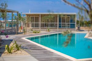 奥米沙利Mobile Homes Camping Omišalj的一栋房子前面有游泳池