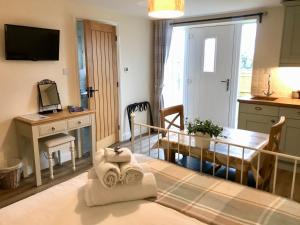 a living room with a table and a dining room at Brinsley Barn in Blagdon