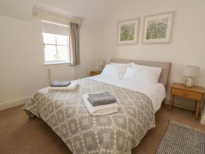 a bedroom with a bed with towels on it at Craigluscar in Newport Pembrokeshire