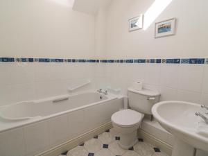 a bathroom with a tub and a toilet and a sink at Craigluscar in Newport Pembrokeshire +23 photos