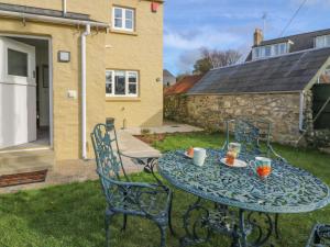 a table and chairs with a plate of food on it at Craigluscar in Newport Pembrokeshire