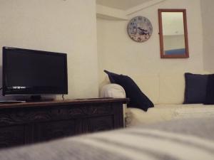 uma sala de estar com uma televisão de ecrã plano numa cómoda em Corner House Guest House em Bideford