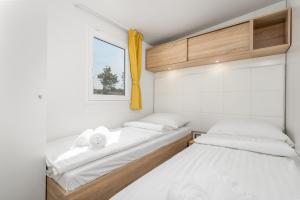 奥米沙利Mobile Homes Camping Omišalj的一间带窗户的小房间里有两张床