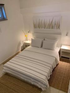 1 cama blanca grande en una habitación con 2 mesas en Linamare en Kiverion