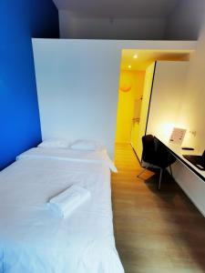 een slaapkamer met een wit bed en een bureau bij Ooostel2.be Zaventem in Zaventem