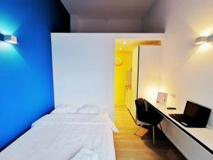 a bedroom with two beds and a desk with a laptop at Ooostel2.be Zaventem in Zaventem