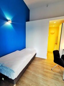 
a bedroom with a bed, chair and a lamp at Ooostel2.be Zaventem in Zaventem
