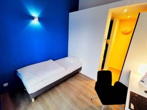 
a room with a bed, chair and a lamp at Ooostel2.be Zaventem in Zaventem
