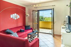 een woonkamer met rode muren en een rode bank bij Relax Apartment in Ladispoli
