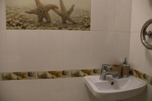 文尼察的住宿－Смарт-квартира на Юності，墙上设有带水槽和两只海星的浴室