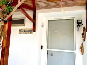 a front door of a house with a blue door at Sounio Golden View Villas in Sounio