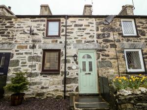 an old stone house with a green door at Bwthyn Y Cwm in Betws-y-coed