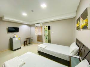 une salle d'hôpital avec deux lits et une télévision dans l'établissement Delighted Bangkok Hotel, à Bangkok