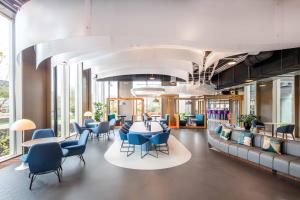 a lobby with blue chairs and tables in a building at YOTEL Amsterdam in Amsterdam