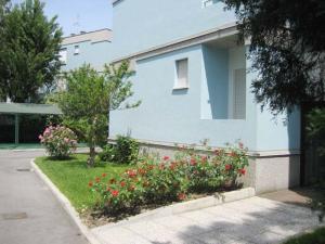 uma casa azul com flores em frente em Villa Clivia em Grado