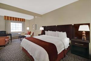 um quarto de hotel com uma cama grande e uma cadeira em Baymont by Wyndham Houston/Westchase em Houston