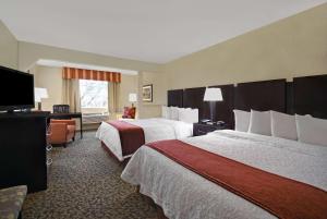 a hotel room with two beds and a flat screen tv at Baymont by Wyndham Houston/Westchase in Houston