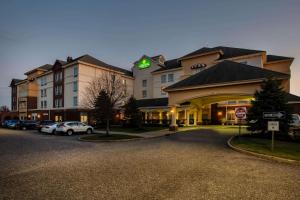 a large hotel with cars parked in a parking lot at La Quinta by Wyndham Islip - MacArthur Airport in Bohemia