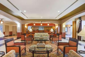 a hotel lobby with chairs and a couch at La Quinta by Wyndham Islip - MacArthur Airport in Bohemia