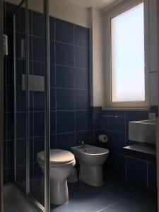 a blue tiled bathroom with a toilet and a sink at Hotel Royal in San Benedetto del Tronto