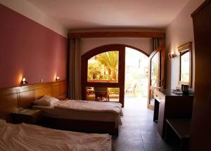 a hotel room with two beds and an archway at Planet Oasis Resort Dahab in Dahab