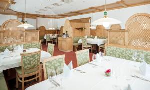 una sala da pranzo con tavoli e sedie bianchi di Die Linde a Höchst