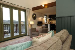 a living room with a couch and a balcony at Faebuie Cottages in Dalchreichart