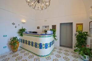 a lobby with a reception desk and a chandelier at Palazzo Talamo in Positano
