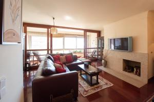 a living room with a couch and a fireplace at Apartamento Portas do Mar I in Matosinhos