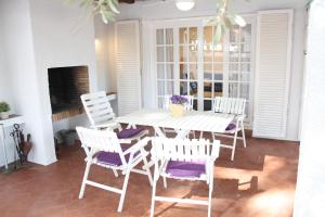 Un comedor con una mesa y sillas blancas. en Cozy marine & spa villa, en Cambrils