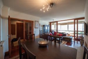 a dining room and living room with a table at Apartamento Portas do Mar I in Matosinhos