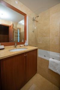 a bathroom with a sink and a shower with a mirror at Apartamento Portas do Mar I in Matosinhos +44 photos