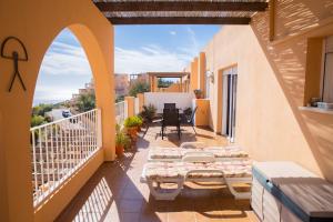 a balcony with chairs and tables on a building at Mojacar, Spain. Penthouse apartment in Mojácar