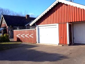 a red and white building with a white garage at 4Stay Vislanda Sauna in Vislanda