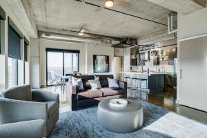 a living room with couches and a table and a kitchen at Sable 901 - Penthouse in Minneapolis