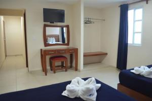 - une chambre d'hôtel avec un lit et un miroir dans l'établissement Progreso Beach Hotel, à Progreso