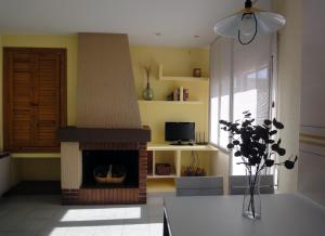 sala de estar con chimenea y TV en CASA AGUILAR, en Castelserás