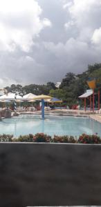 a swimming pool with umbrellas and tables and chairs at CHALES AABB SALVADOR(BA) in Salvador