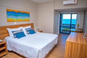 um quarto com uma cama grande e almofadas azuis em Grande Hotel da Barra em Salvador