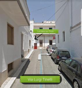 a street with cars parked on the side of a building at La casa sui trulli in Alberobello