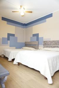 ein Schlafzimmer mit zwei Betten und einem Deckenventilator in der Unterkunft Hotel Palacio in Xalapa + 26 Fotos